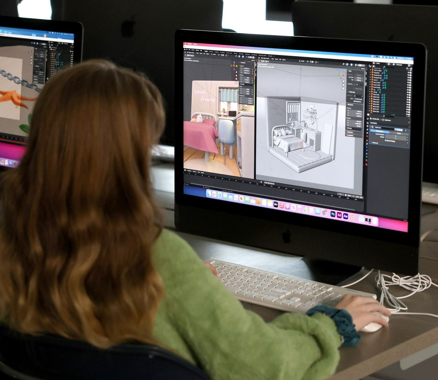 A person with long hair and a green sweater uses a computer displaying 3D interior design software, focused on creating a room layout.