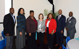 Well-wishers pose for a final staff photo with Karen Nippert: Interim Vice-President of Finance and Administration Mike Neal, Executive Director of Communications, Marketing and Community Relations Daphne Thomas; Vice President of Student Service Jacqueline Taylor, Nippert, President Tracy D. Hall, Chief Information Officer Michael Boyd, and Executive Assistant to the President Sherman Greer. 