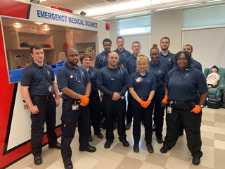 Emergency Medical Technician students at the Macon Cove Campus show off the new ambulance simulator.