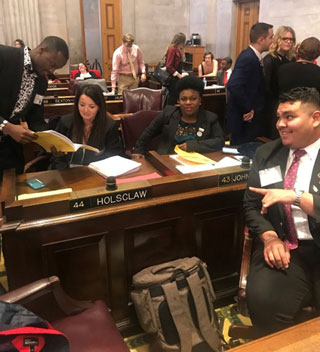 Carl Slappy, Jr. (at left) reviews the media bill with staff from Representative John B. Holsclaw’s office. 