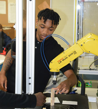 A Southwest student learns how to operate a robotic arm. 