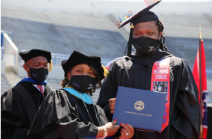 Southwest President Tracy D. Hall presents a diploma to an engineering student. 