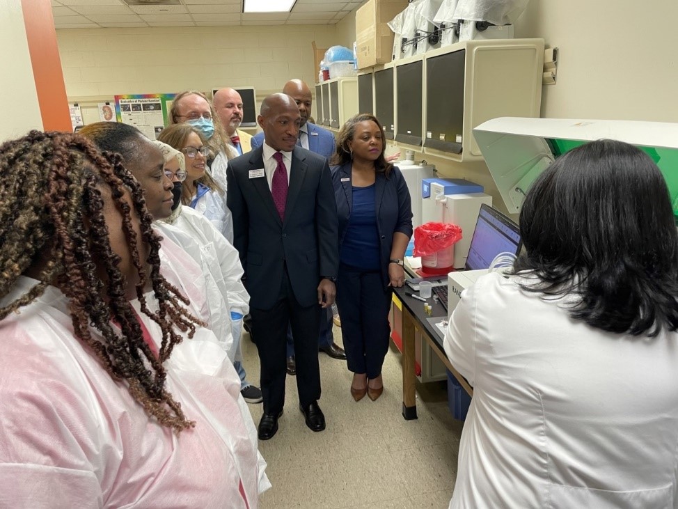 Senior medical laboratory technician students stand with Southwest Tennessee Community College  President Tracy D. Hall and Vice President of Academic Affairs Dr. Kendricks Hooker while Associate Professor of Allied Health Shilpa Desai demonstrates how a Randox chemistry analyzer works.