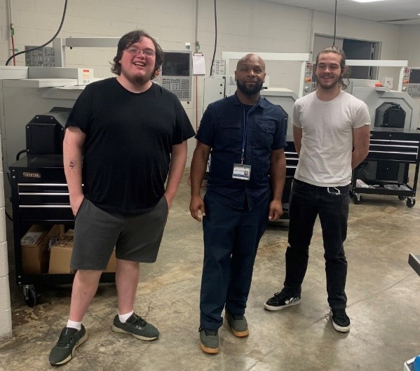 Arlington High School dual enrollment students David Grinstead and Seth Haslip stand beside Southwest technologies instructor Antonio Hayes (middle).