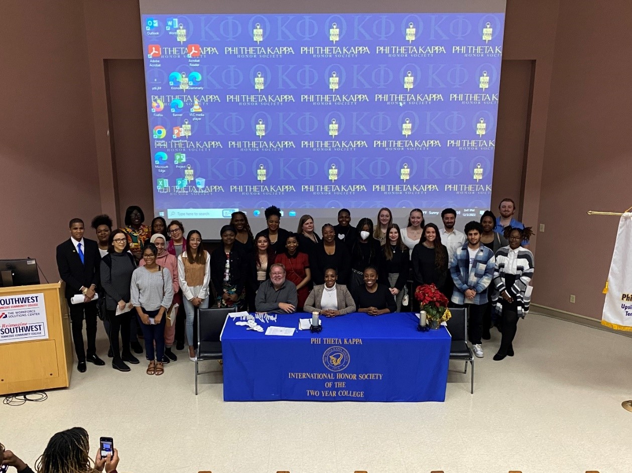 The newest members of the Upsilon Delta Chapter of PTK stand behind (front row) faculty advisor Douglas Branch, keynote speaker Fredrica Tyes and co-advisor Dr. Melanie Jones at the fall 2023 induction ceremony. 