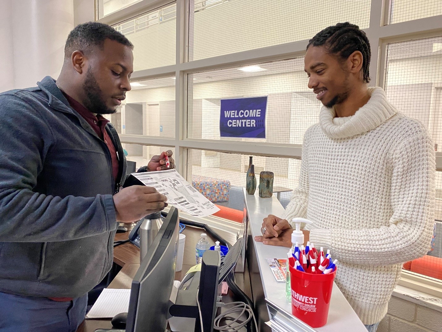 Enrollment Specialist Joshua Payne assistists student Joshua Branscomb inside the Macon Cove Campus Welcome Center. 