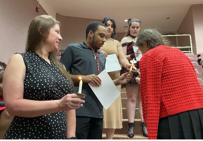 Phi Theta Kappa Vice-president for Public Relations, Ariana Harter, lights the candles of newly inducted members of the Upsilon Delta Chapter. 