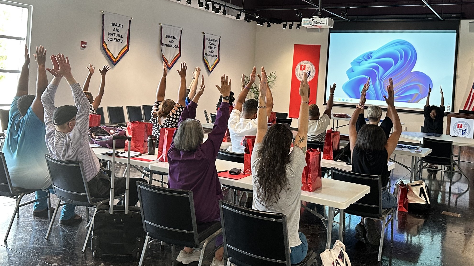 Faculty and staff participate in a chair yoga exercise at the inaugural back-to-campus health retreat.