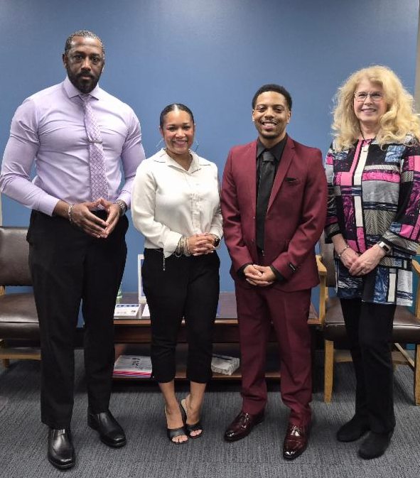 2 men and 2 women standing and smiling